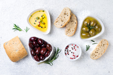 Ciabatta bread, olives, oil, herbs and spices on white background. Mediterranean or italian snacks. Top view