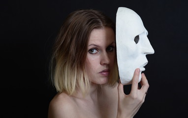 The actress holds a white theatrical mask