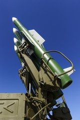 Ballistic missile launcher with four cruise missiles on powerful mobile transportation with blue sky on background, antiaircraft forces, military industry 