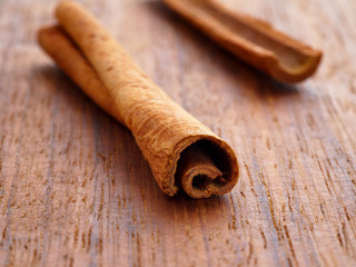 Cinnamon sticks on wooden background. Macro shot.
