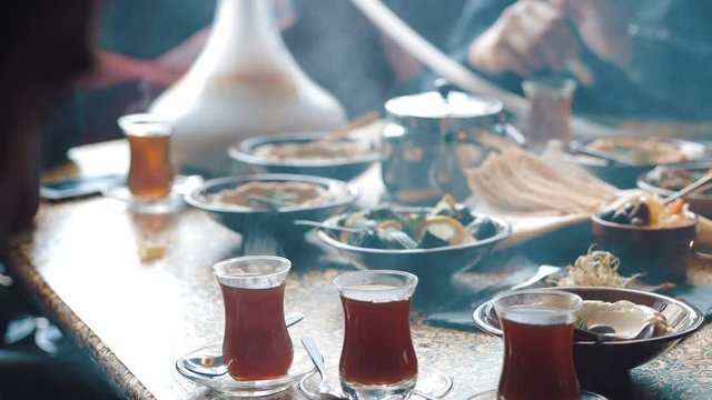 Young company is having fun and eating in bar. smoking a hookah, communicating in an oriental restaurant.