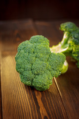 Big and ripe broccoli florets on wooden table.