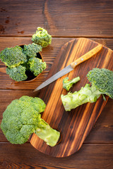 Fresh organic broccoli, cutted on kitchen board.