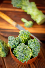 Fresh organic broccoli, cutted on kitchen board.