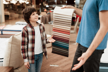Man with young boy chooses color on color palette. Selecting color of mattress on color palette guide
