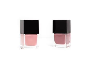 Two bottles of nail polish or lacquer in mauve and light pink or rose colors on white background