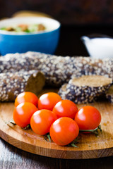 Hip of cherry tomatoes over the wooden board.