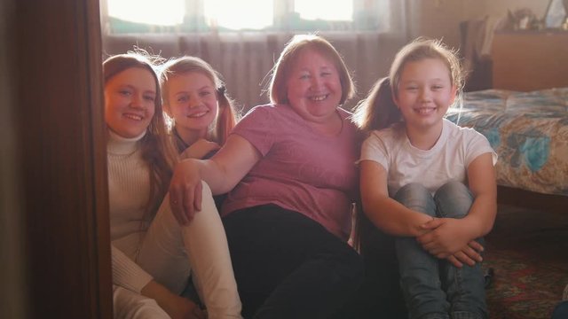 Happy family photographed - three teen girls and grandmother