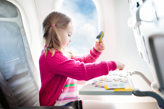 Child in airplane. Fly with family. Kids travel.