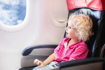 Child flying in airplane. Flight with kids.