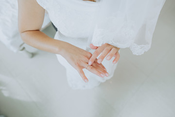Fototapeta na wymiar hands bride ring finger folded against white wedding dress