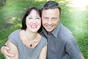 middle aged mature couple in green garden make a selfie with smartphone phone