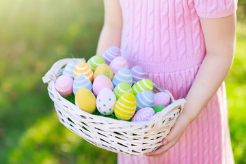 Fototapeta na wymiar Kids on Easter egg hunt with eggs basket.