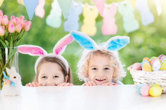 Kids with bunny ears and eggs on Easter egg hunt.