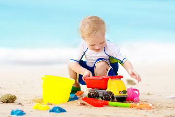 Kids play on tropical beach. Sand and water toy.