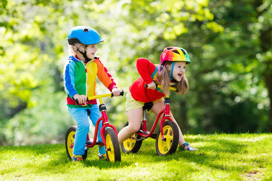 Kids ride balance bike in park