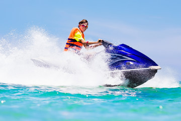 Teenager on jet ski. Teen age boy water skiing.