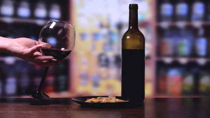 Wine test, crystal glass, red wine, cheese, bar counter background.