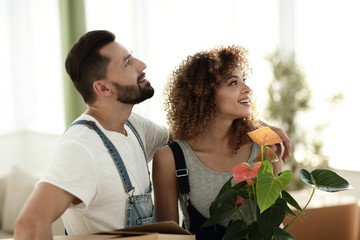 young family brings boxes with things to a new apartment.