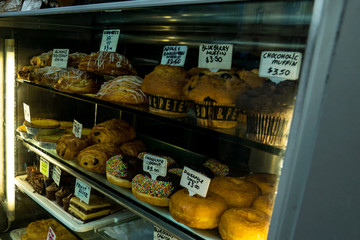 Traditional pastries and coffee stand with donuts, muffins and chocolate bread.
