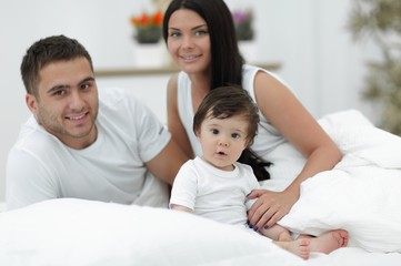Obraz premium Cheerful family having fun together lying on a bed