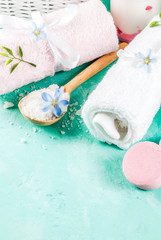 Spa relax and bath concept, sea salt, soap, with cosmetics and towels on light blue concrete background, copy space