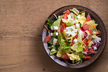 Grapefruit, tomato, lettuce and cucumber salad with feta cheese. Clean eating, healthy and diet food concept. View from above, top