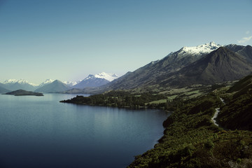 Naklejka na ściany i meble Paisaje de montañas con picos nevados. Las montañas se reflejan en un lago. Escena diurna, cielo azul y despejado. Nueva Zelanda.