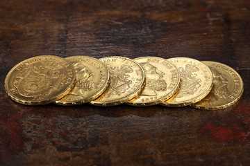 Belgian 20 Francs gold coins on rustic wooden background
