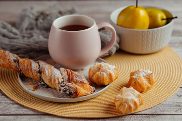 Delicious homemade cakes and desserts. Cream profitroles with sugar powder on plate on white wooden background