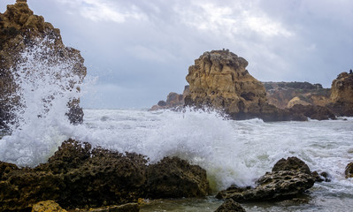 Wild and stormy sea crashing on coastal rocks