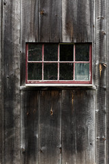 Red framed wooden window on a barn