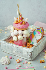 Freak shake decorated as unicorn in the wooden box filled with popcorn