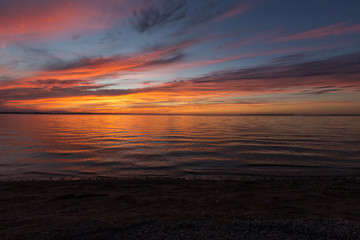 Fototapeta na wymiar Orange, yellow and purple sunset over a quiet lake