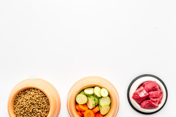Ingredients for dry pet food. Meat and vegetables zucchini and carrot on white backgroud top view copy space