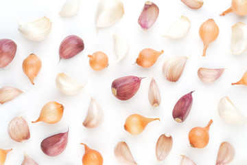 Onion and garlic isolated on white background, top view. Wallpaper abstract composition of vegetables.