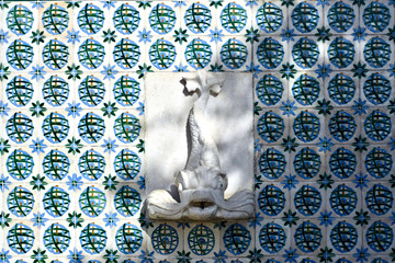 Fonte branca em Lisboa, com fundo de azulejo português azul , numa rua de Lisboa, Portugal