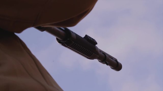 Male training with shotgun  outdoors in field. Hunter with rifle, 