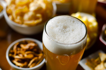 pint of lager beer in a glass, set of various snacks, a standard set of drinking and eating in a pub