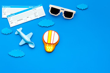Sample of airplane ticket. Traveling with family and child. Glasses and plane model on blue background top view mock up