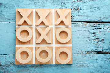 Wooden tic tac toe game on blue table