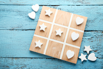 Wooden tic tac toe game on blue table