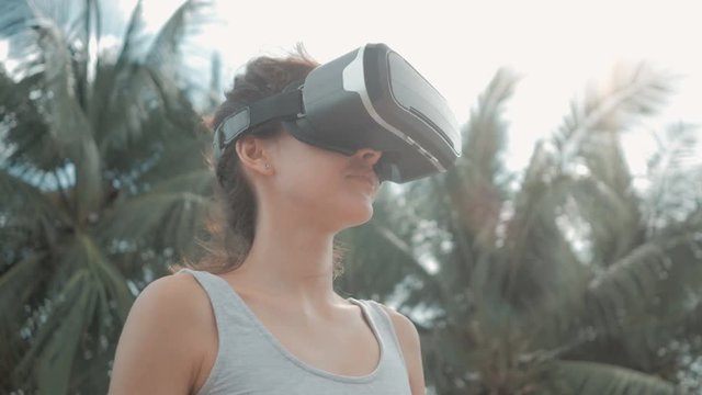 Happy young woman wearing virtual reality headset dancing