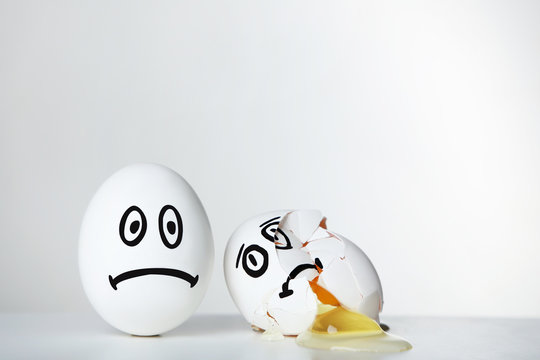 Eggs with funny faces on grey background