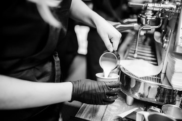 Barista women use jar pouring milk on hot coffee