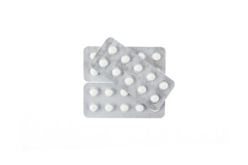three plates of white pills on white isolated background