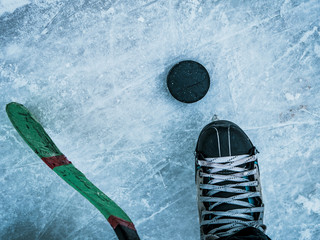 hockey puck stick and skates on ice texture top down view with copyspace