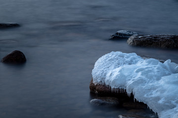 Fototapeta na wymiar Close up of ice and snow on a rock on the coast