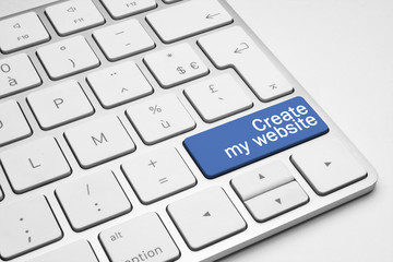 Blue Create my website button on keyboard on a white background