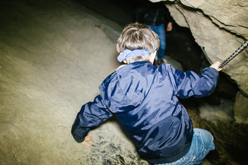 children explore underground caves, an underground karst complex of Cunardo, Lombardy, Italy